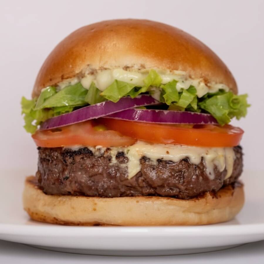 O "X Salada" é composto por uma camada generosa de alface americana crocante, rodelas de tomate suculentas e cebola fresca, adicionando um toque de frescor ao hambúrguer. Para completar, um delicioso queijo derretido e uma maionese verde, que transforma cada mordida em uma experiência de sabor única.