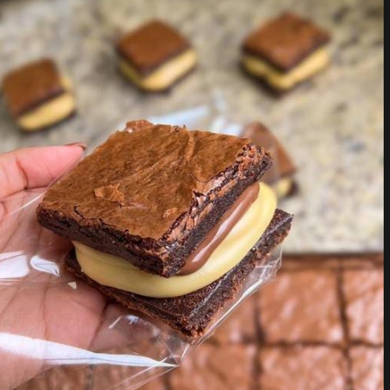 Quadradinho de Brownie Ninho com Nutella Uma sobremesa que conquista no primeiro pedaço! Brownie macio e chocolatudo, coberto com creme de leite Ninho irresistível e finalizado com generosa camada de Nutella. A combinação perfeita entre intensidade e suavidade, feita para adoçar qualquer momento.