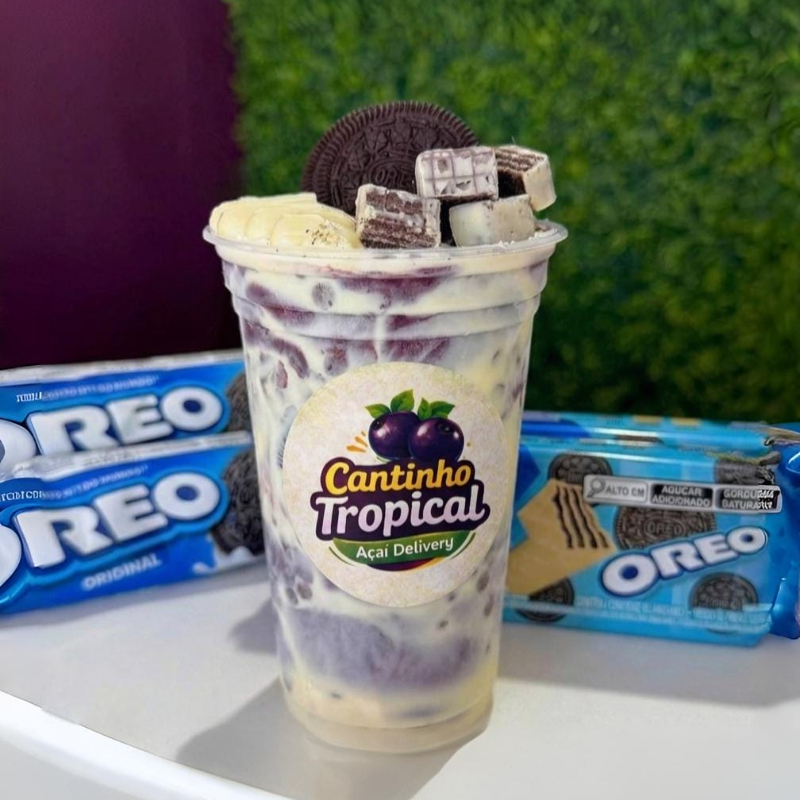 Açaí · creme de avelã · Oreo triturado · leite condensado · leite em pó · e fruta a sua escolha. O encontro mais viciante do cardápio. Açaí cremoso com creme de avelã e pedaços generosos de Oreo quebrando em cada colherada. O crocante do biscoito contra o cremoso do açaí cria uma experiência que parece sobremesa de restaurante — no conforto da sua casa. Uma vez você pede, da segunda em diante você já sabe o que vai querer.