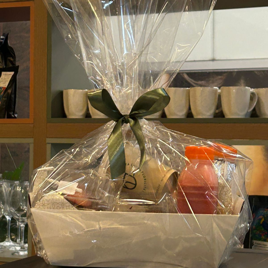 Cesta composta por: 1 croissant com manteiga; 1 brownie; 1 folhado de canela; 1 cookie de cereja com chocolate; 1 bolo de maça com nozes; 1 suco natural laranja; 1 potinho geleia de frutas vermelhas