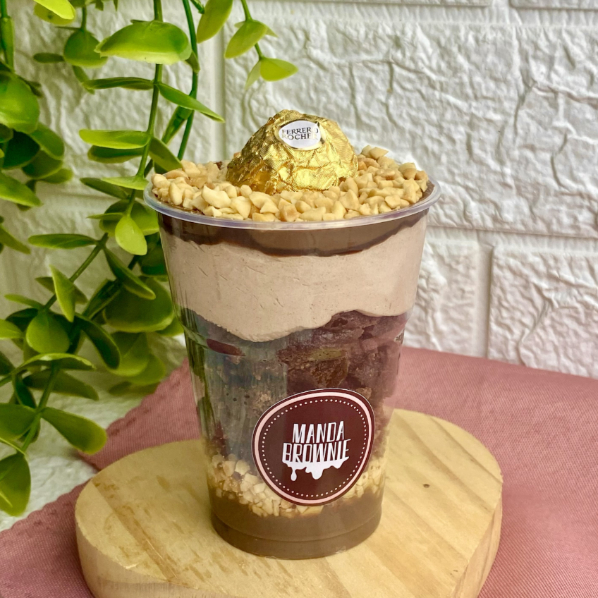 Nobreza define esse copo! Artesanal em deliciosas camadas: recheio cremoso de chocolate cacau 50%, o nosso Manda Brownie com chocolate nobre na massa, amendoim em flocos, mousse cremosa de chocolate, finalizado com Nutella pura e bombom Ferrero Rocher. Nós sabemos que você deseja esse copo, então peça já! Peso médio 250g