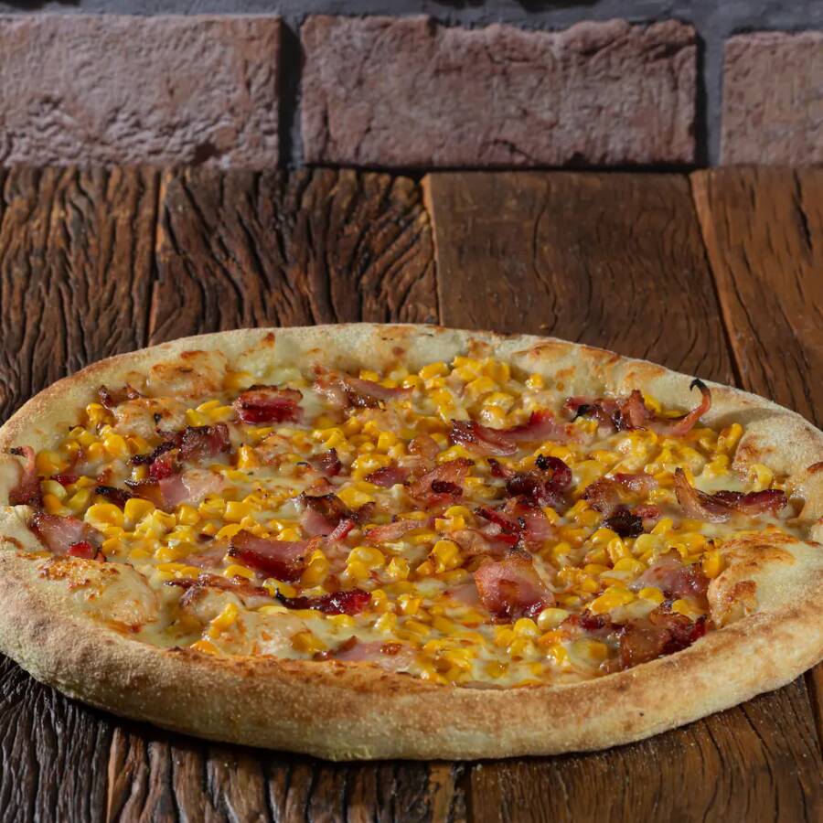 Uma combinação irresistível de milho doce e bacon crocante, sobre uma base de queijo mussarela e molho de tomate.