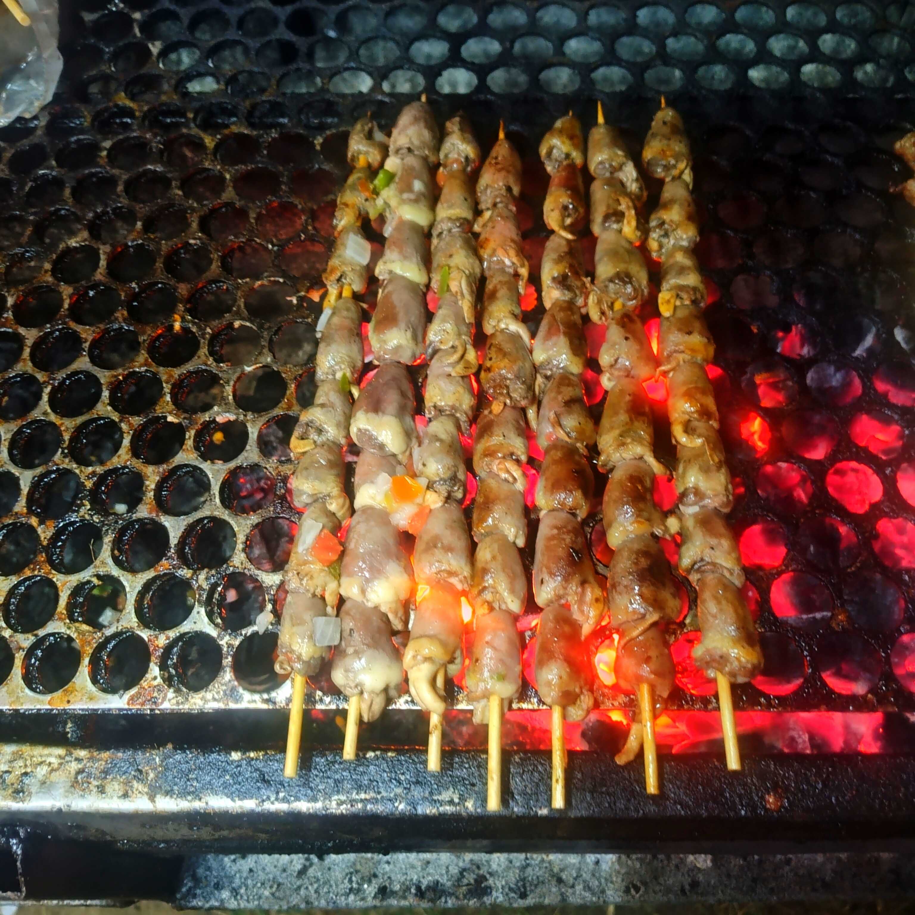 Corações de frango temperados e grelhados no espeto, perfeitos para um churrasco saboroso.