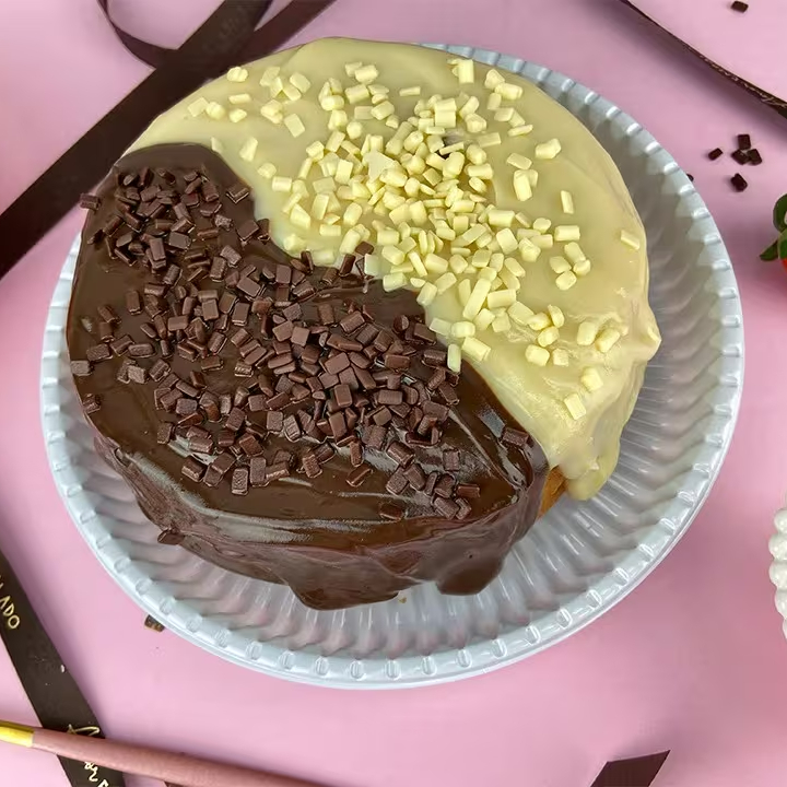 Massa: bolo de chocolate Recheio/Calda: calda de brigadeiro Cobertura/Decoração: metade com calda de brigadeiro; outra metade com calda de Ninho Finalização: raspas de chocolate ao leite e leite em pó