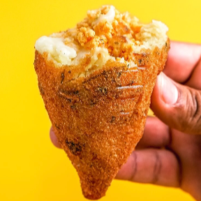 Coxinha de frango com massa de batata e recheio de frango triturado e temperado.