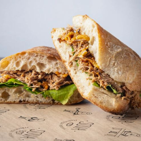 Carne assada desfiada, queijo serra da canastra meia cura, cebola roxa branqueada, rúcula e molho aioli na ciabatta