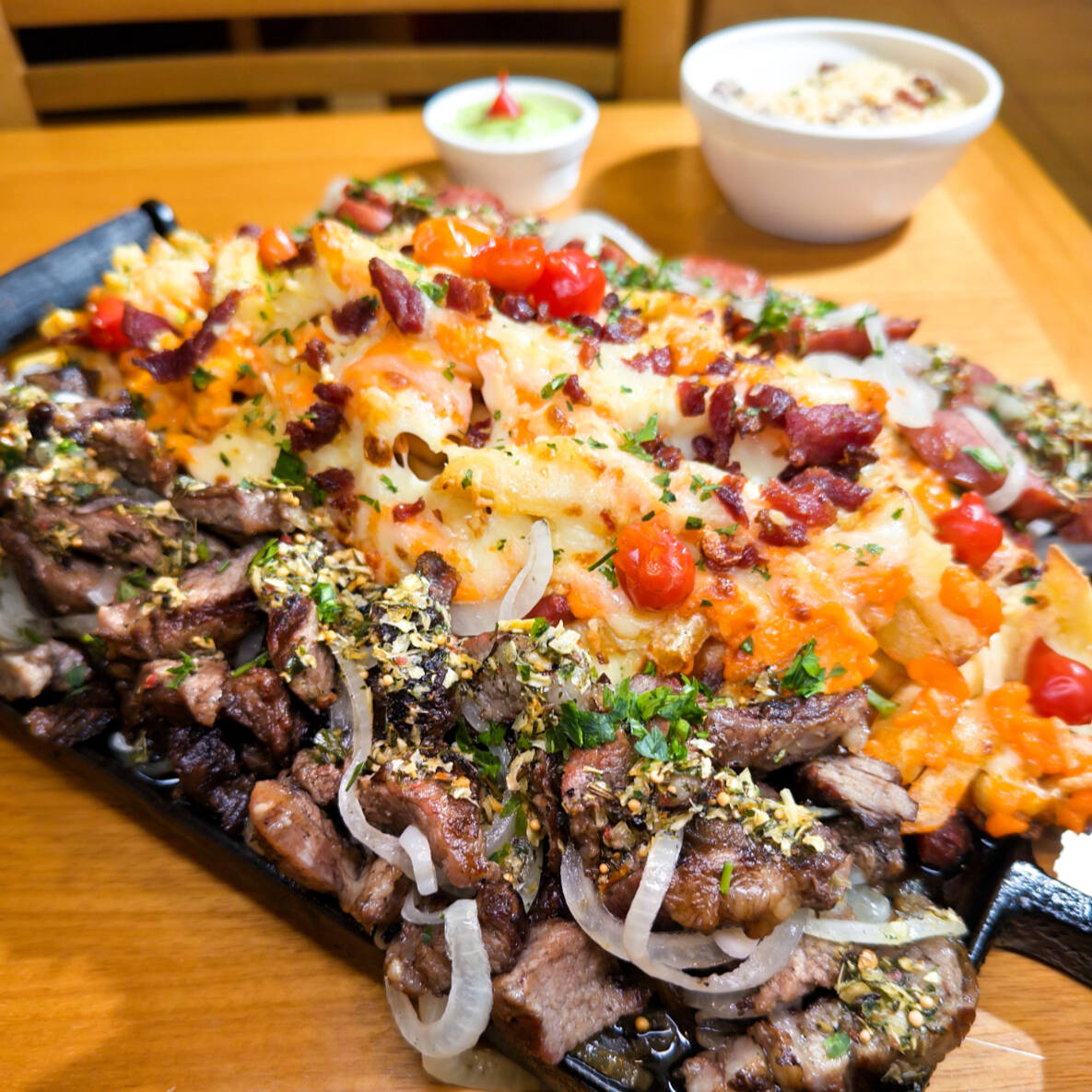 Tiras de Ancho acebolado, rodelas de calabresa acebolada e flambada e Batatas Fritas com chedder e bacon. Servido com molho Grill