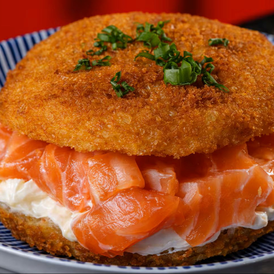 Com Suculento Salmão Fresco, Levemente Temperado E Moldado Em Formato De Hambúrguer De Arroz, É Coberto Com Uma Camada De Cream Cheese E Um Toque De Molho Tarê.