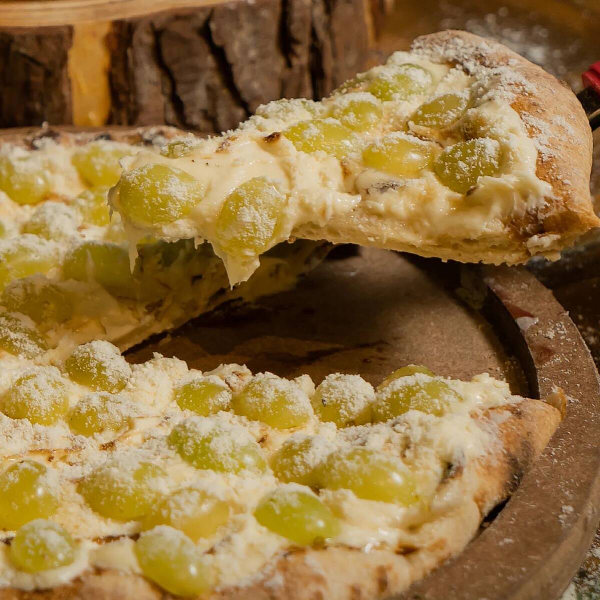 Pizza doce de chocolate branco com uva verde fresca, cremosa e com contraste perfeito entre o doce e o frescor da fruta.