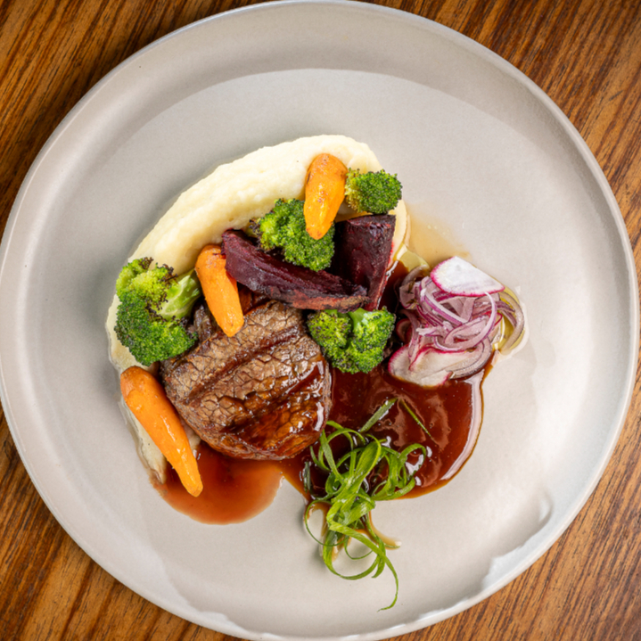 Filé mignon, alto ao ponto perfeito, com purê de batata, mix de legumes cozido ao vapor, demi-glace artesanal e farofa de maracujá.