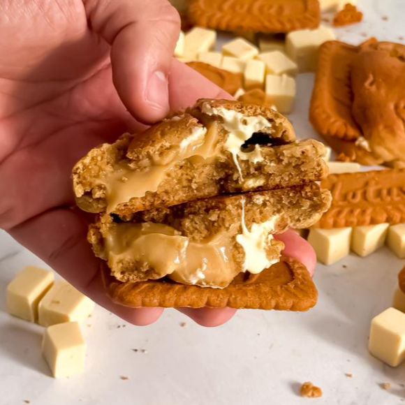 Cookie Lótus Biscoff, inspirado no famoso biscoito belga. Massa com um toque de canela e gotas de chocolate branco, recheado com brigadeiro Biscoff e finalizado com o próprio biscoito.