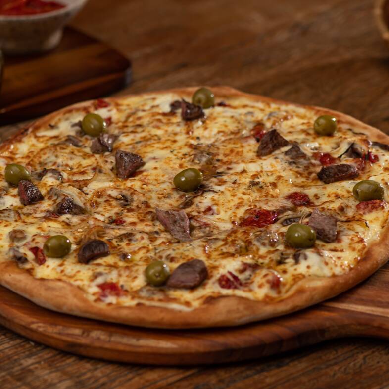 Molho de tomate Italiano, tomate seco, filé mignon, Catupiry, cebola, muçarela, orégano, alho frito e azeitonas verdes sem caroço.