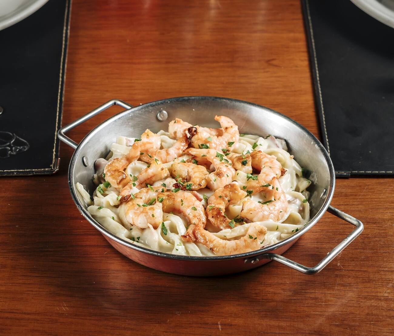 Camarão grelhado sobre fettuccine com molho alfredo e bacon.