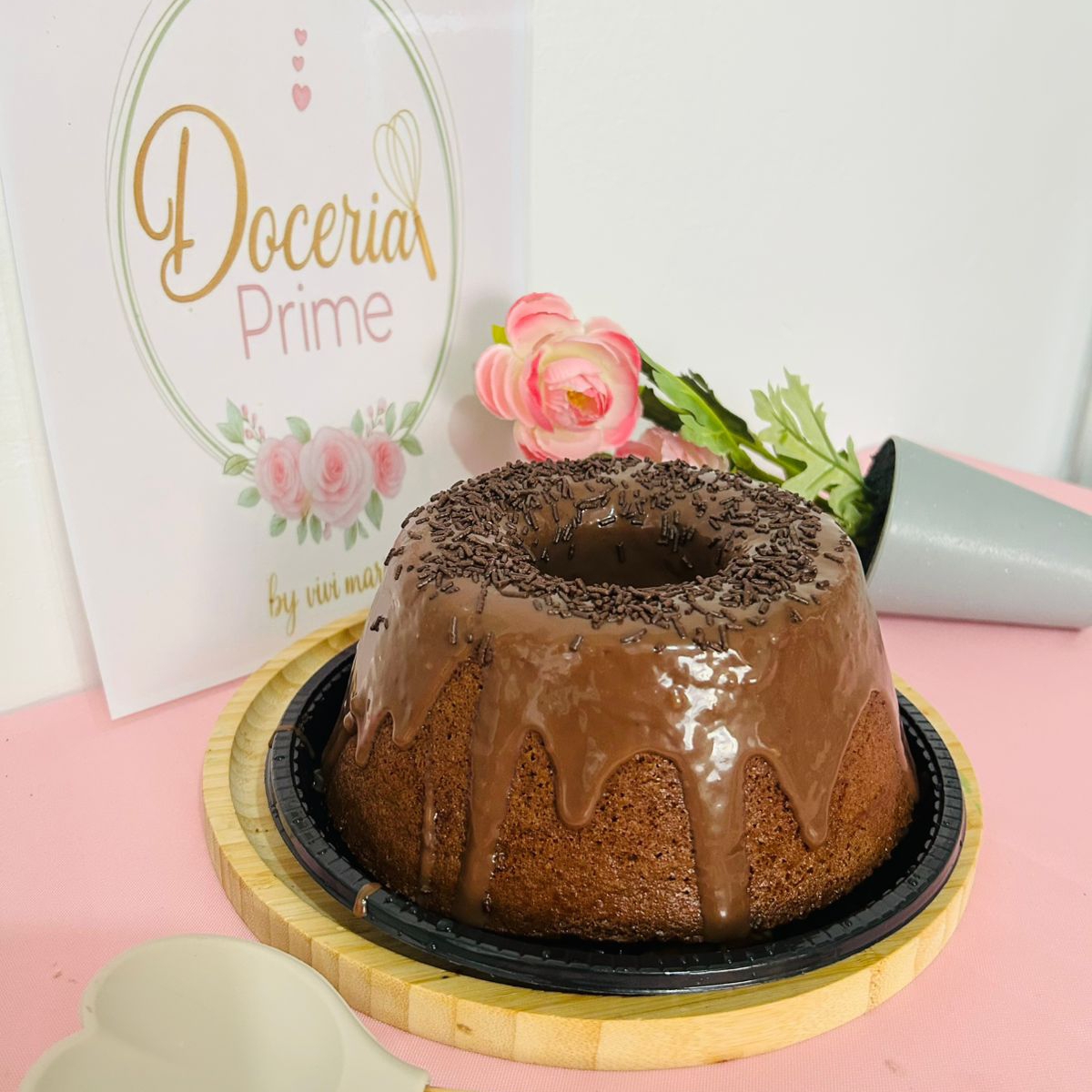 bolo massa de chocolate, com cobertura de chocolate e granulado por cima.