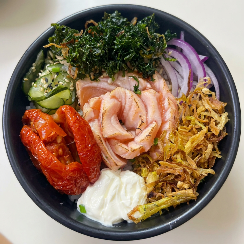 Arroz japones, laminas de salmão maçaricado, tomate seco, crisp de couve, cebola roxa, sunomono , crean chesse, gergelim, geleia sweet sauce, cebolinha, molho do chef.