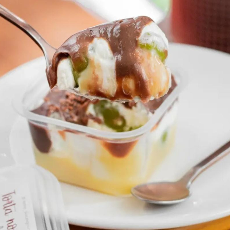 É composto por 3 camadas de cremes artesanais (creme de chocolate 50% cacau, creme de chantininho, creme de Ninho) intercalados com uvas verdes sem caroço.