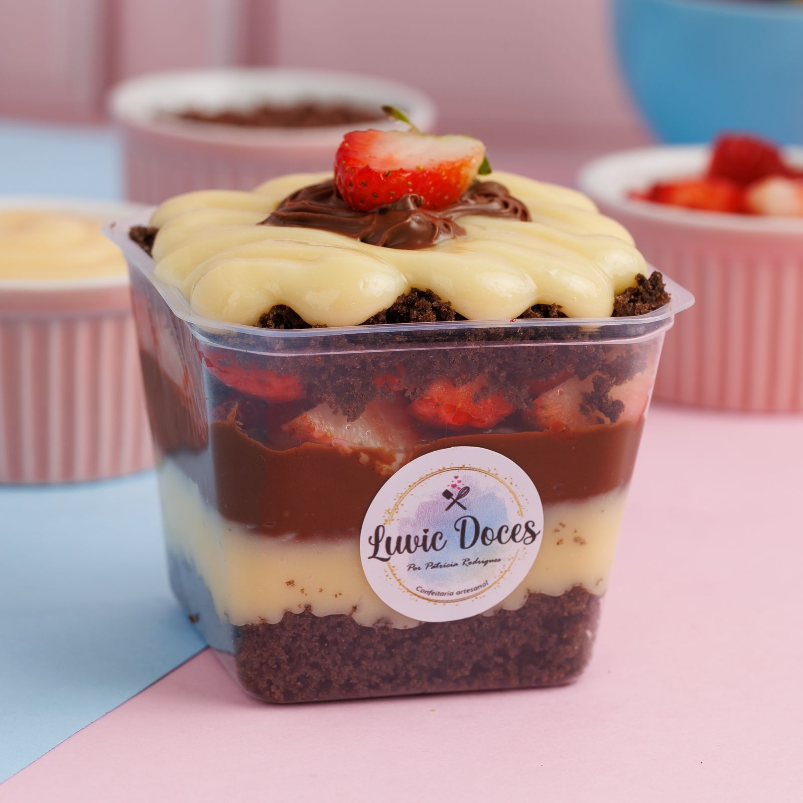 Descubra a magia do nosso Bolo no Pote Ninho, Morango e Nutella, pesando cerca de 250g. A categoria pertence aos irresistíveis Bolos Gelados no Pote. Este prato se destaca por sua massa de chocolate incrivelmente fofinha e umedecida na medida certa, recheada com um creme suave e sedoso de leite Ninho. Para finalizar, este prato é realçado pela doçura dos morangos frescos e o sabor inconfundível da