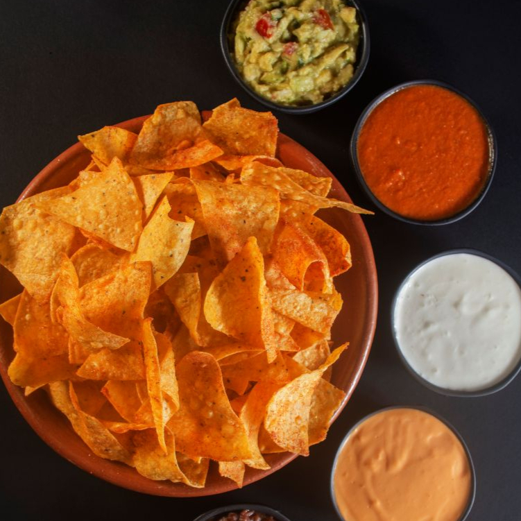 Farta porção de tortilhas de milho acompanhados por: 200 ml de Guacamole 200 ml de Chilli beans  120 ml de Sour cream  120 ml de molho cheddar  30 ml de pimenta de tequila   Molhos enviados separadamente  Possibilidades de troca a serem avaliadas pela loja :)