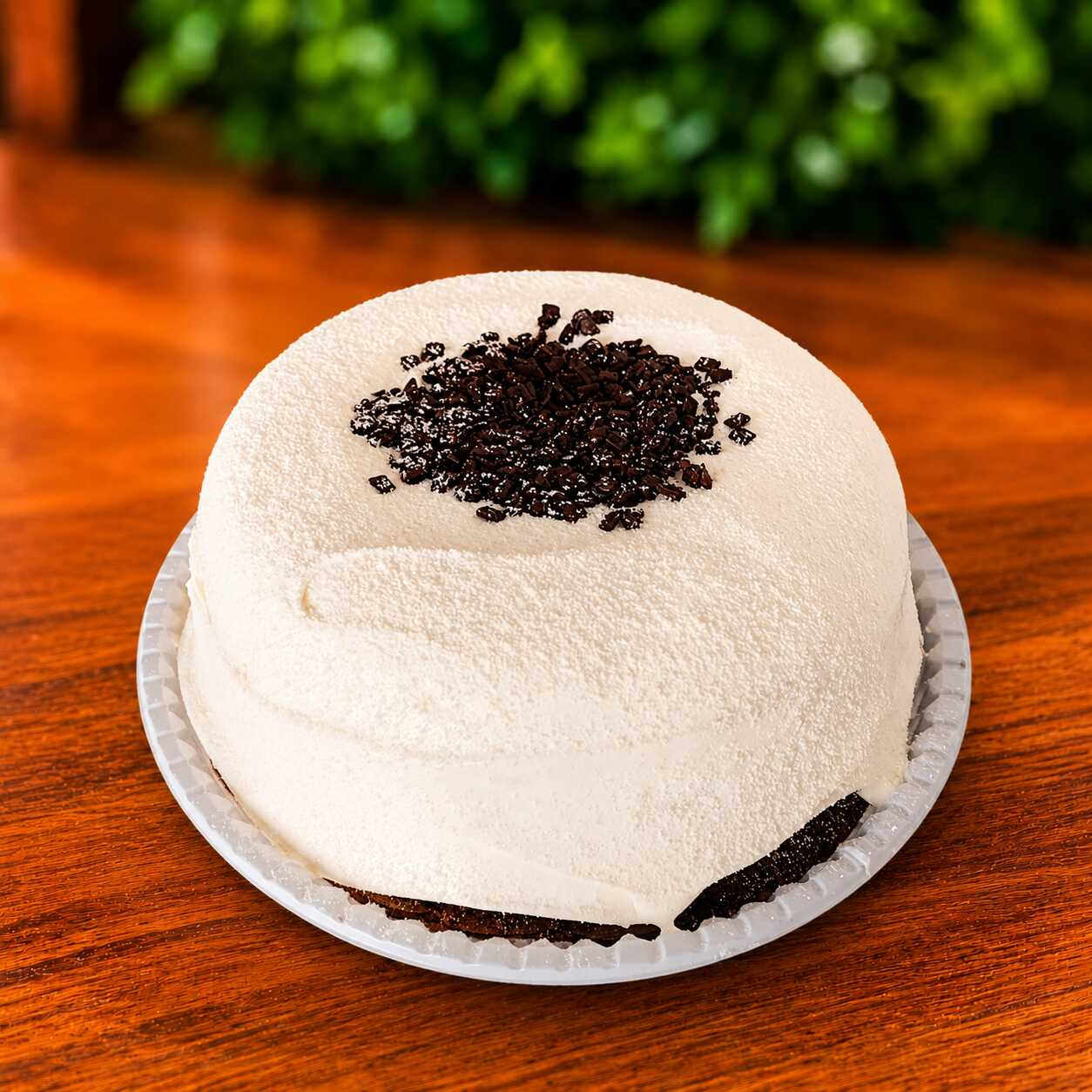 Bolo vulcão de creme de Ninho, conhecido pela sua textura leve e sabor suave, que envolve toda a sobremesa de forma delicada. No topo, gotas de chocolate adicionam um contraste equilibrado, trazendo intensidade e um toque levemente crocante. Uma combinação simples e harmoniosa, com destaque para a cremosidade e o sabor clássico.