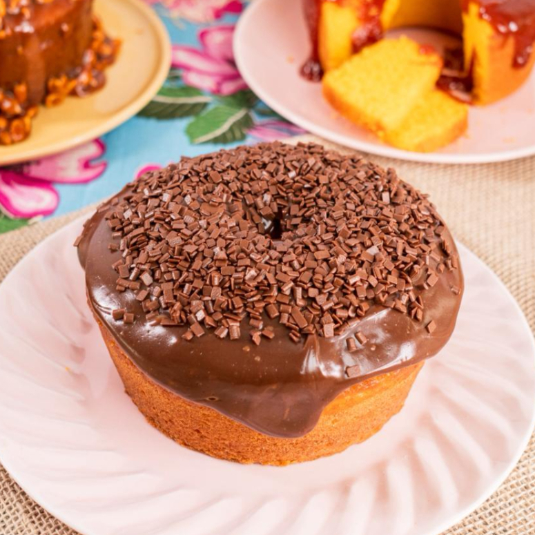 Bolo de Laranja, feito com laranja natural e suco da fruta na massa, cobertura de brigadeiro belga. Sabor intenso e caseiro!