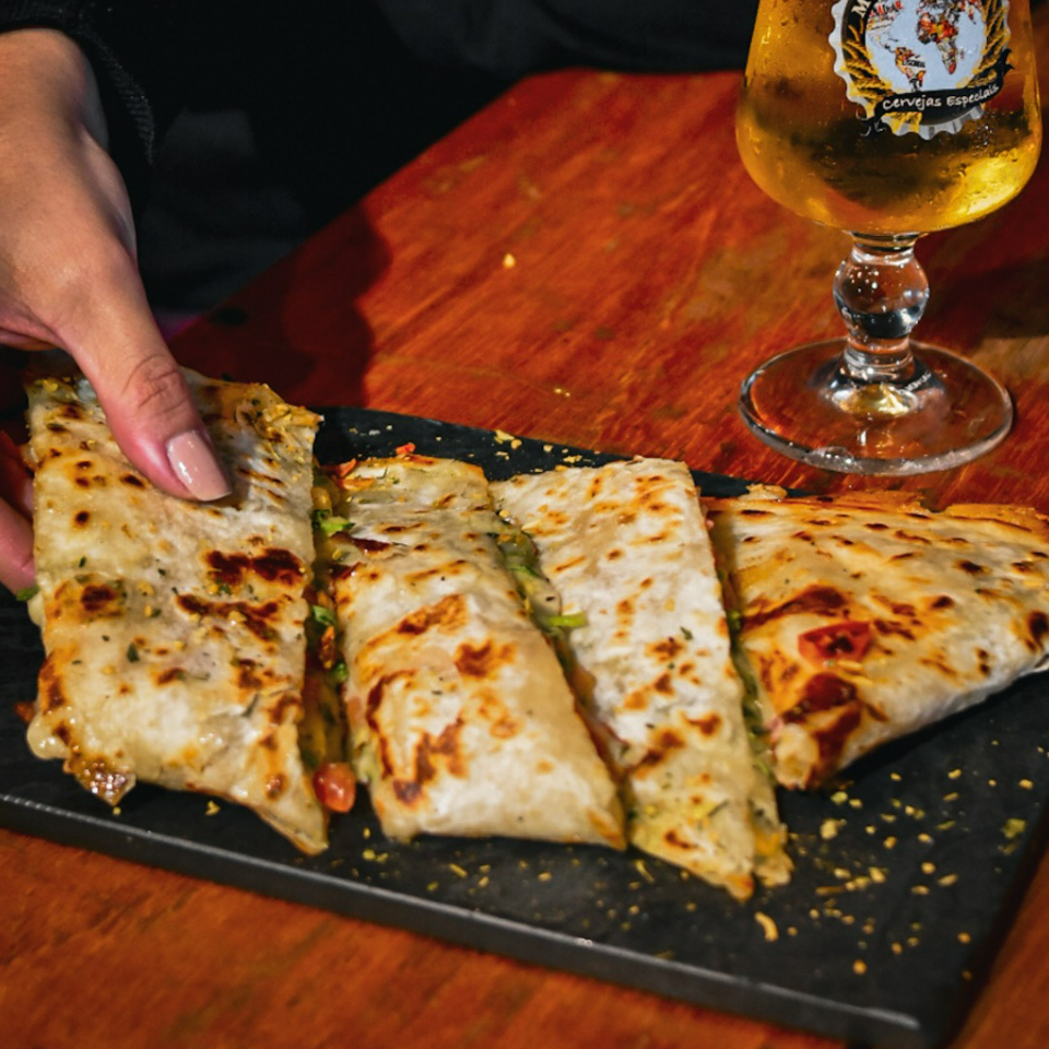 Lombo suíno desfiado e marinado na stout, cebola roxa, barbecue e queijo.