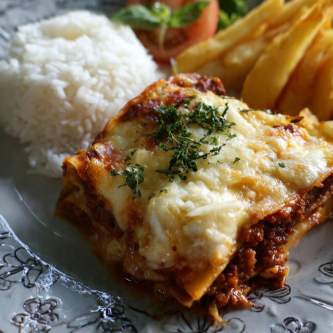 Lasanha à bolonhesa acompanhada de uma porção de arroz, uma de batata palha (Elma Chips) e um refrigerante de 200ml de sua preferência
