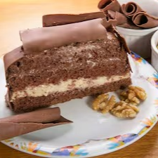 Pão de ló de chocolate super macio, recheado com brigadeiro cremoso e doce de nozes, coberto com mais brigadeiro e finalizado com raspas de chocolate ao leite. Uma combinação clássica com um toque especial que derrete na boca!