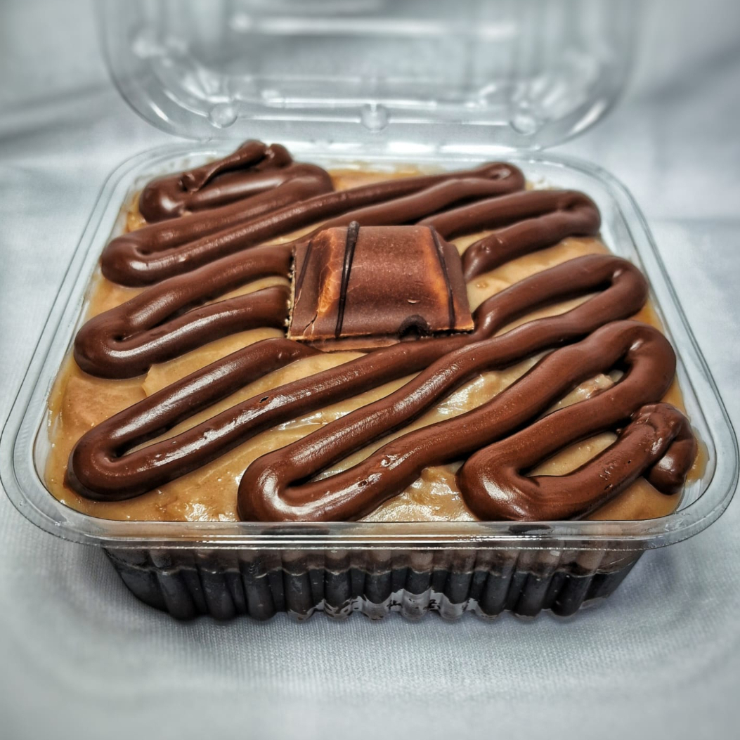 Bolo de chocolate 50% cacau molhadinho com calda de chocolate, recheio cremoso tipo Kinder Bueno com riscos de Nutella, finalizado com um pedaço de Kinder Bueno.