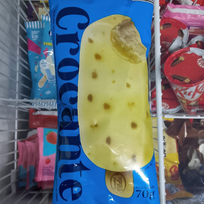 Picolé sabor chocolate branco com cobertura de chocolate branco e castanha de caju caramelizada. 70 ga