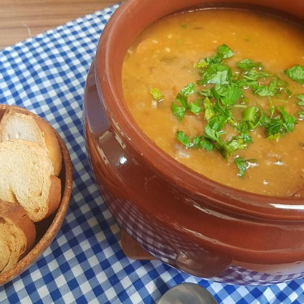 Nosso Caldo de Mocotó é uma verdadeira celebração de sabor e tradição, com um toque especial que o torna único. Preparado com o caldo aveludado e nutritivo do mocotó, a receita ganha robustez com bacon crocante e calabresa triturada, adicionando um sabor defumado e picante que é irresistível. A harmonia perfeita é alcançada com a inclusão de pimentão vermelho e amarelo, que trazem uma leve doçura e uma cor vibrante à sopa. Finalizamos com o frescor do coentro e o nosso tempero caseiro que eleva cada colherada. Servido com um pãozinho fresquinho, este caldo é a definição de uma experiência gastronômica completa, que aquece e conforta.