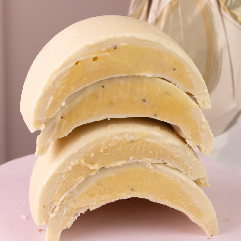 Ovo trufado com duas bandas de chocolate nobre branco, recheadas com ganache de maracujá feita com a própria fruta. Acompanha sacola presente Dandoce