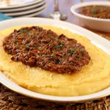 Este prato especial, a Polenta Cremosa com Ragu, é uma verdadeira tentação. Uma polenta maravilhosamente deliciosa, meticulosamente preparada com um caldo de legumes frescos, enriquecida com a suavidade da manteiga e a intensidade do queijo parmesão. Acompanha um molho pomodoro, preparado à perfeição, que acrescenta um toque robusto e saboroso a este prato. Cada garfada promete uma experiência gas