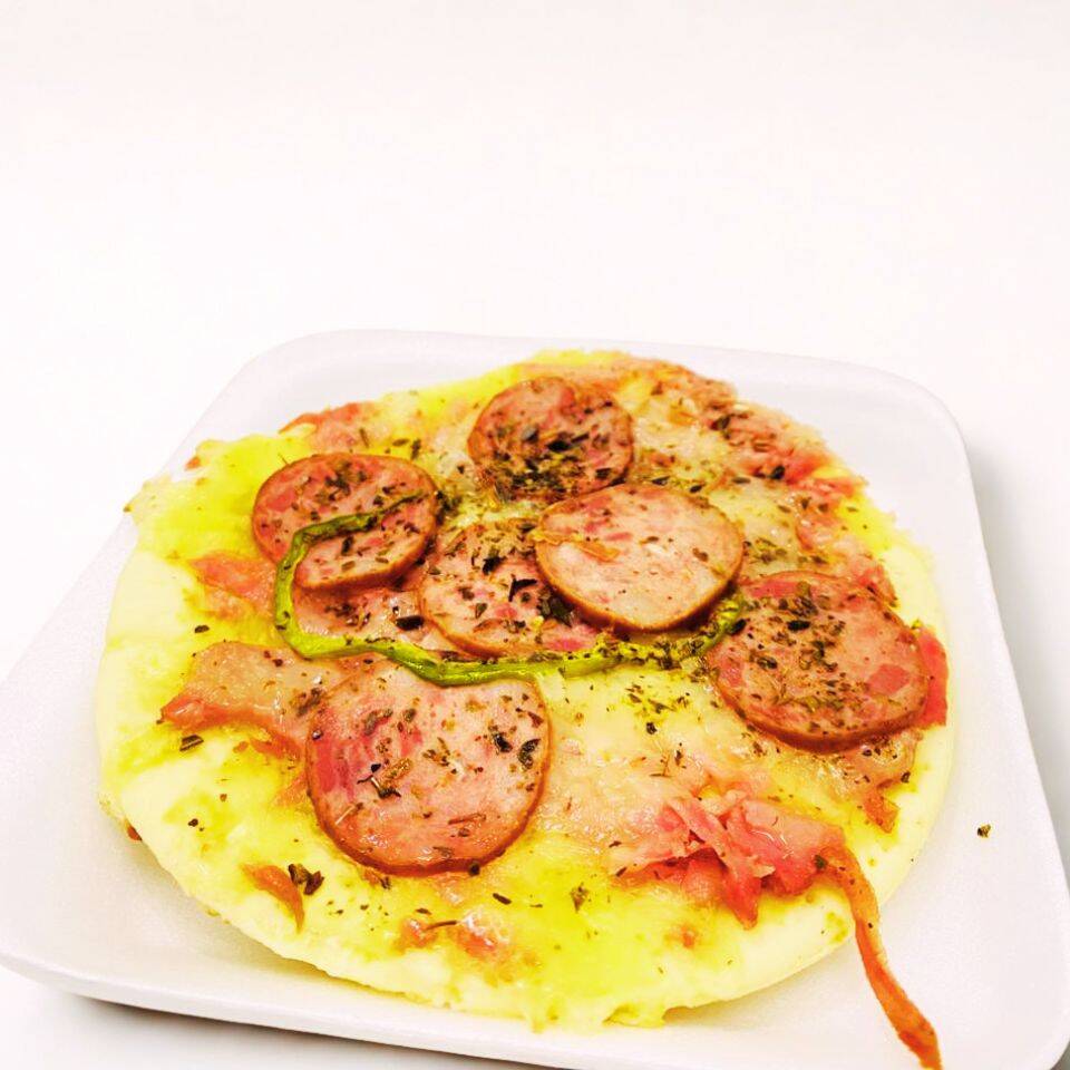 Fatia de pizza com calabresa temperada e queijo derretido.