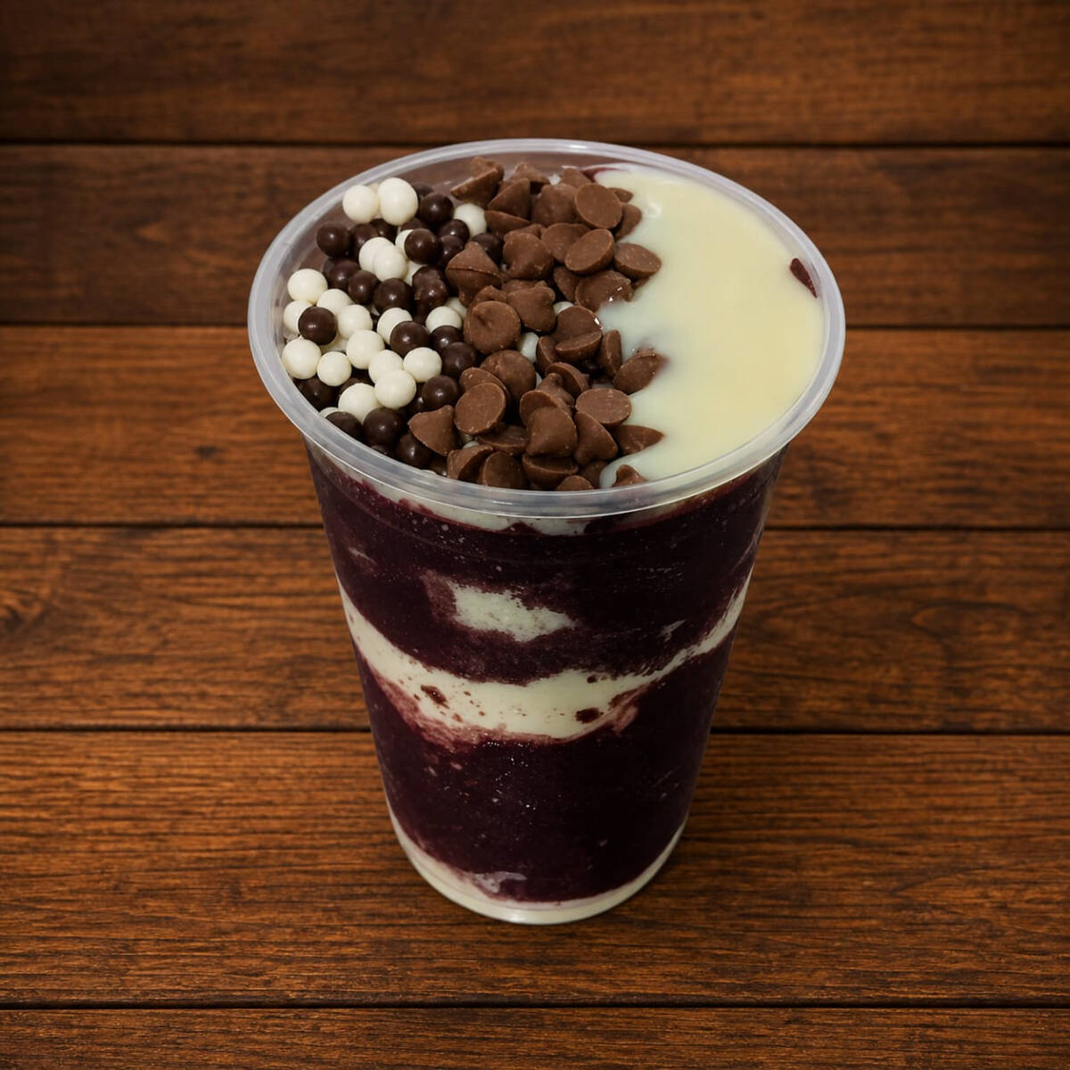 Açaí super cremoso montado em camadas de leite em pó e leite condensado e no topo 3 adicionais de sua escolha