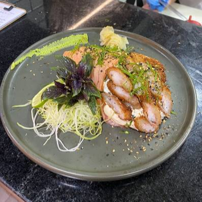 Manta de salmão maçaricada, recheio de camarão empanado, cream cheese, arroz japonês, finalizado com camarões empanados, cebolinho e gergelim.