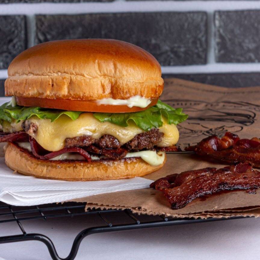 Hambúrguer com carne de 100g, queijo cheddar fatiado, bacon crocante, alface, tomate e molho Big no pão especial selado.