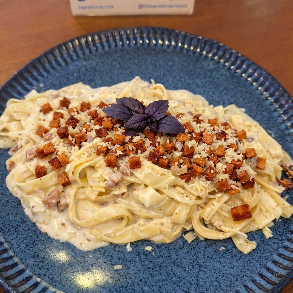 Talharim ao molho carbonara cremoso, preparado com ovos, queijo parmesão e bacon crocante. Sabor tradicional italiano em um prato irresistível.