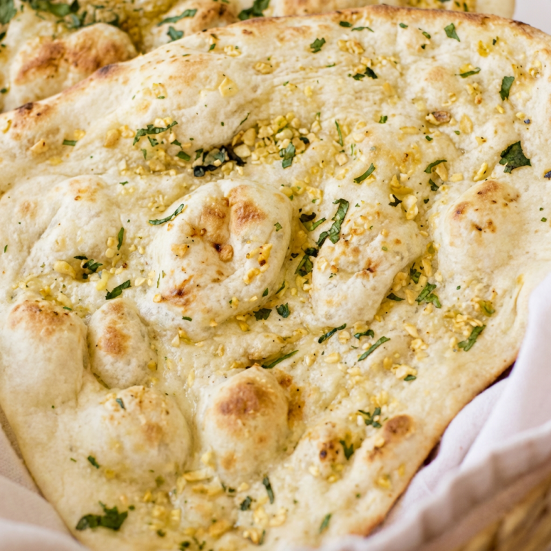 Pão indiano com alho e manteiga assado no forno Tandoor. (massa feita de trigo e iogurte)