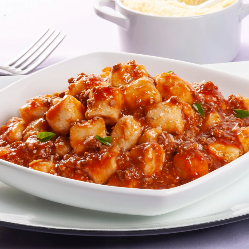 nhoque ao molho bolonhesa acompanhado com milho e palmito