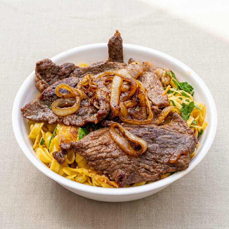 Suculento bife grelhado no ponto perfeito,coberto com cebolas douradas e caramelizadas. Acompanha nosso feijão temperado da casa (branco e preto), arroz soltinho e macarrão al dente. Uma refeição completa que mata a fome e aquece o coração!
