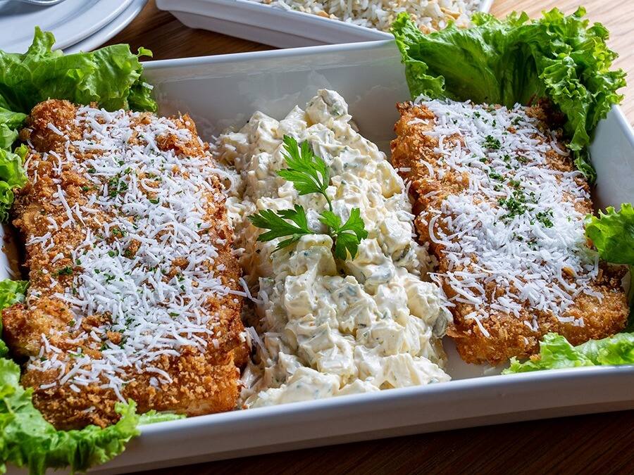 Filé de Peixe Empanado ao Coco Levemente Adocicado e Farinha de Paes Frescos, Crocante Por Fora e Macio Por Dentro. Acompanha Arroz de Castanha e Maionese de Batata com Picles de Pepino.