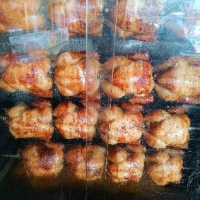 Frango assado tradicional, acompanhado de uma porção de batata no molho de alho e farofa.