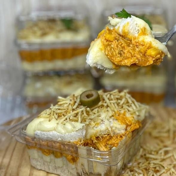 Camadas intercaladas de pão macio, frango desfiado temperado, requeijão e batata palha.