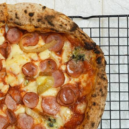 Massa de fermentação natural, molho de tomate, mozzarella fiordilatte, linguiça calabresa, gorgonzola, cebola caramelizada e mel levemente picante