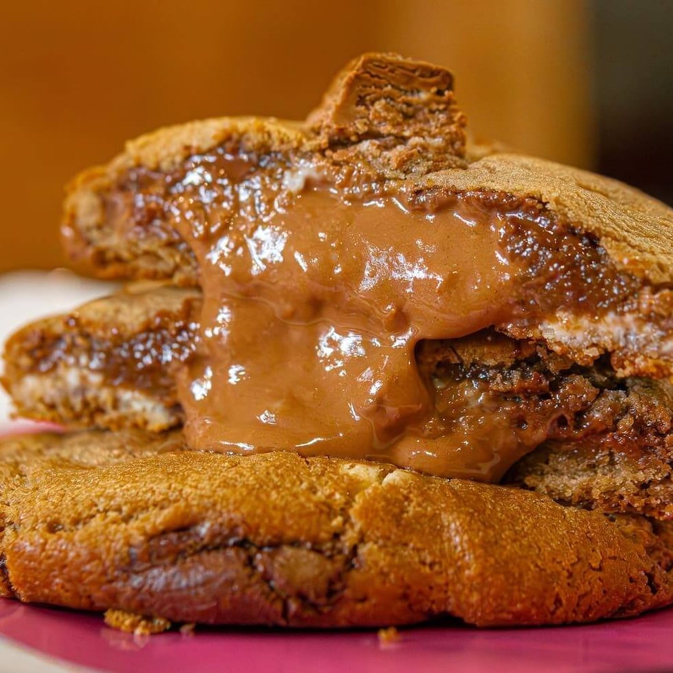 Cookie feito com nossa massa tradicional de baunilha com gotas de chocolate ao leite e gotas de chocolate meio amargo recheado com creme de Kit Kat!