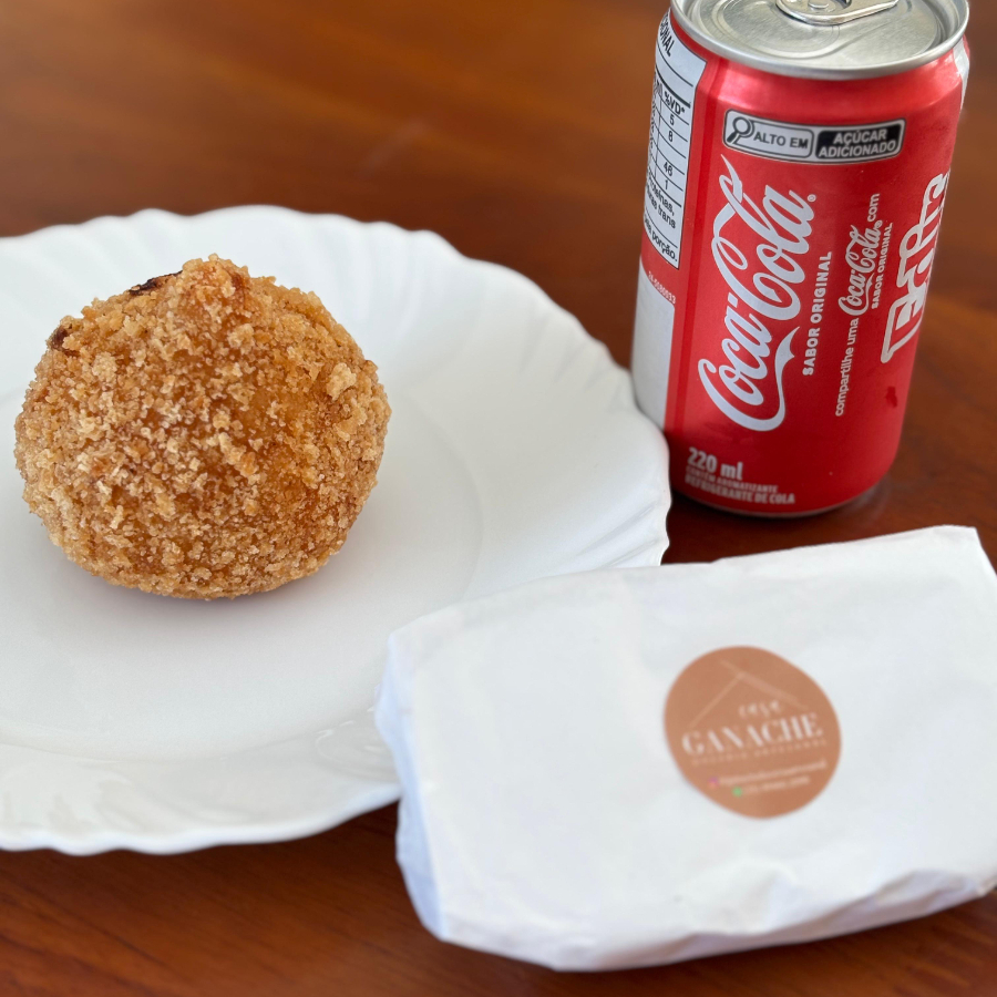Uma coxinha de frango, uma fatia de bolo gelado e um refrigerante
