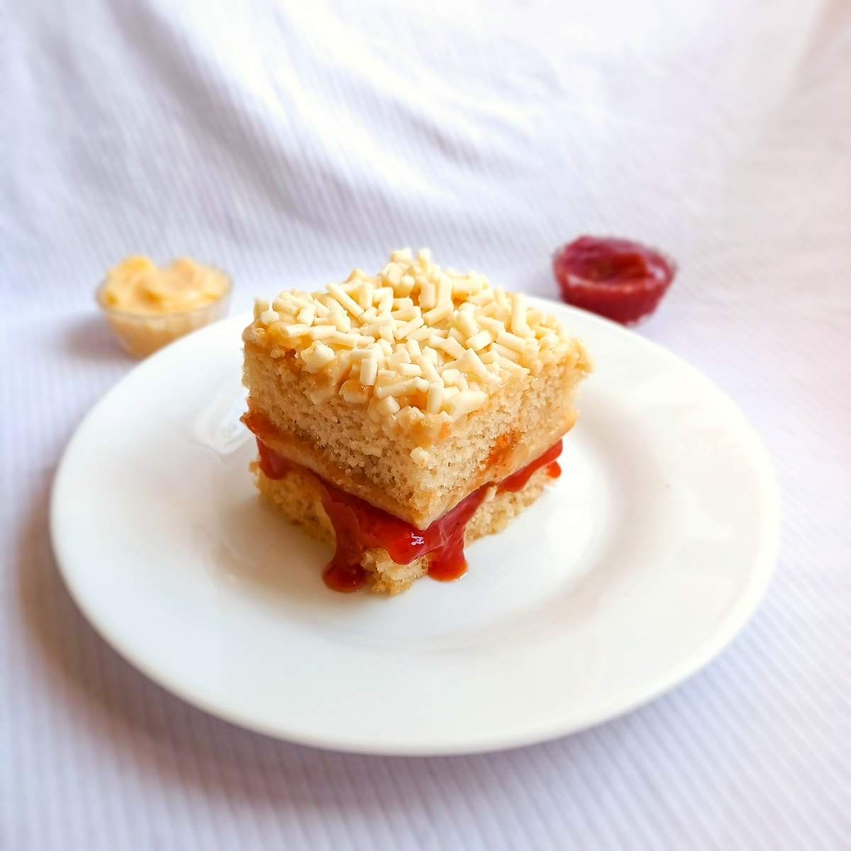 Esqueça tudo o que você já provou sobre bolo gelado, essa é uma história de amor em forma de sobremesa! Massa super fofinha de baunilha, molhadinha na medida, recheada com brigadeiro cremoso de queijo parmesão ralado e goiabada cremosa. A cobertura segue com o recheio apaixonante de queijo parmesão e é finalizada com flakes artesanais. Uma releitura do clássico Romeu e Julieta, feita com carinho e ousadia. Vai embrulhado no tradicional papel alumínio, como todo bom bolo gelado deve ser! Bolo gelado artesanal | Romeu e Julieta gourmet | Bolo de goiabada com queijo em Recife. Peso aproximado: 100g Alérgicos: Contén glúten, leite e derivados.