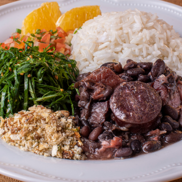 Feijoada Saborosa e Bem Temperada com Arroz Soltinho, Couve Refogada, Torresmo Crocante e Farofa Dourada.
