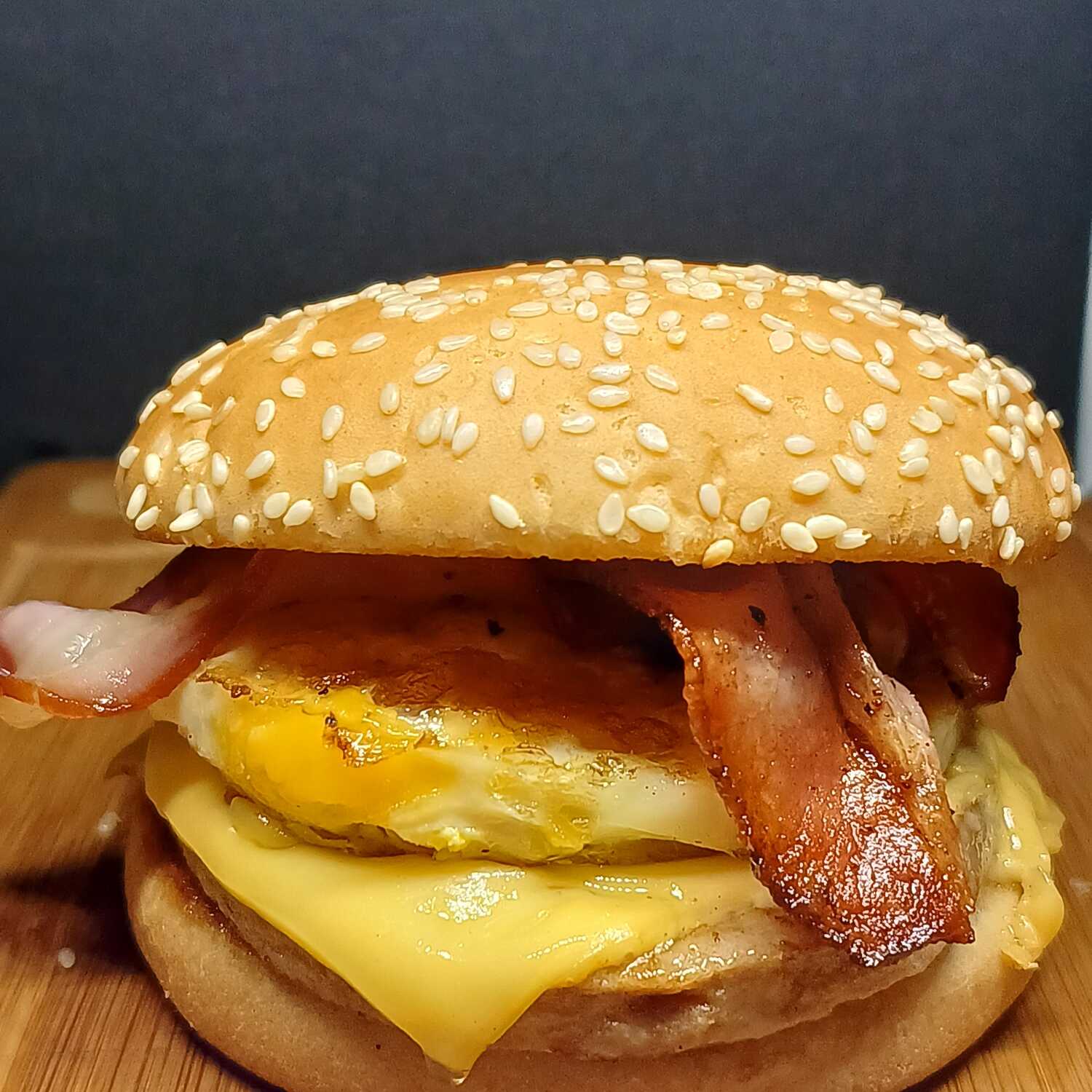 Feito com pão tradicional salpicado com gergelim, saborosa carne de 56g, ovo frito na chapa e no ponto, bacon, queijo derretendo e molho Gourmezi. Acompanha maionese temperada.
