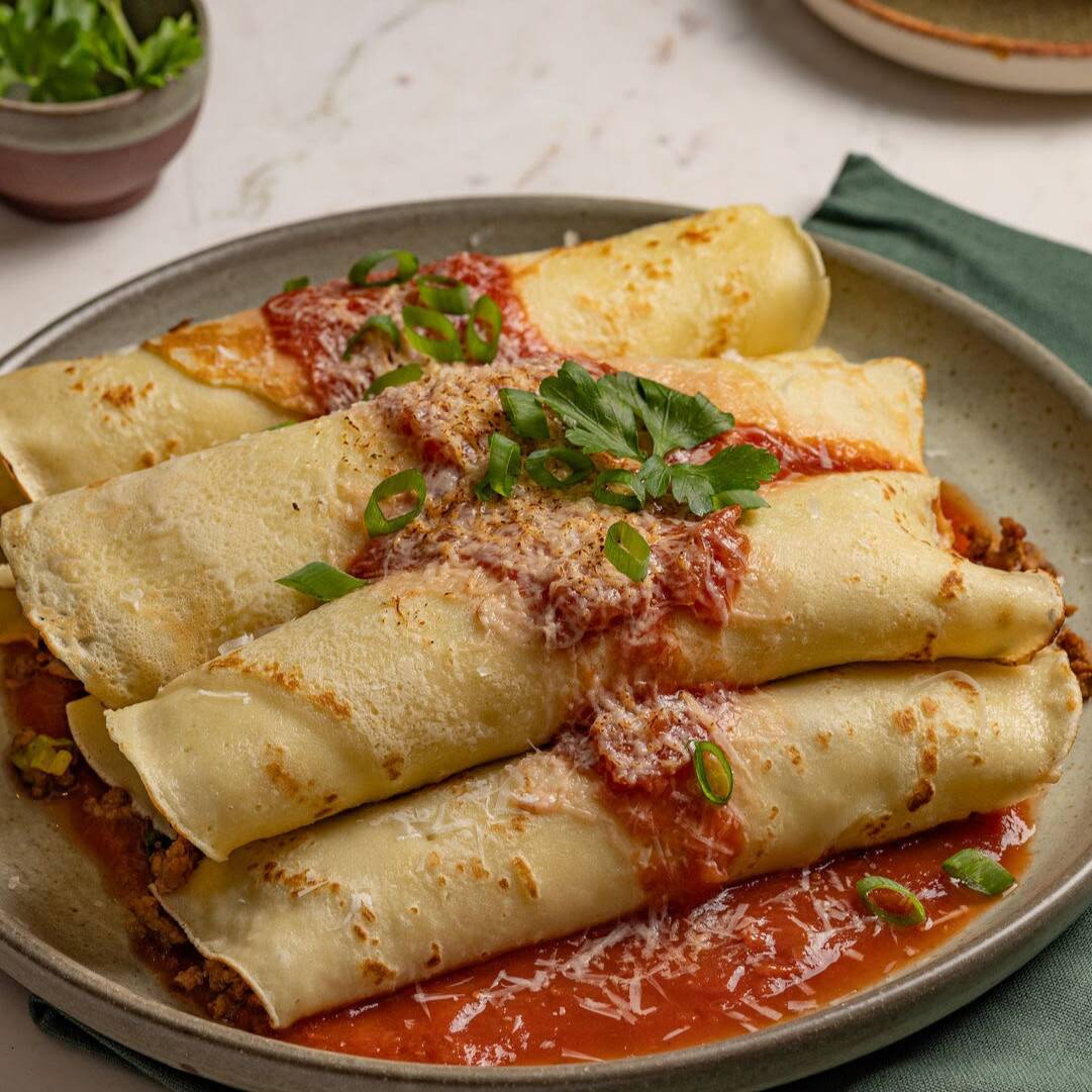 Deliciosa panqueca recheada com carne moída temperada, coberta com molho de tomate e finalizada com queijo gratinado. Servida sem acompanhamento.